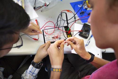 学生在电子工程实验室制作电路板