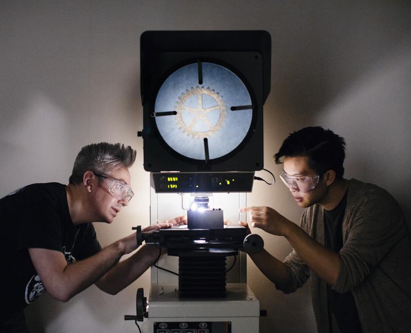 两个学生在材料实验室里检查一个齿轮